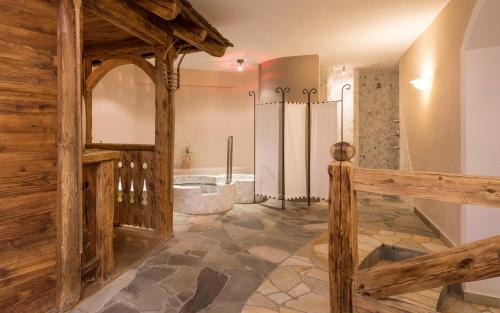 a large bathroom with a tub and a walk in shower at Hotel Zirmerhof & Residence in Rifiano