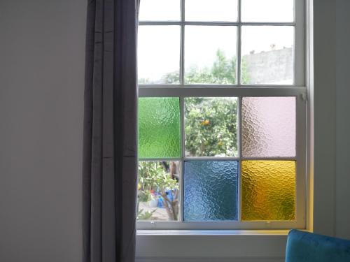 a view of a window with a colorful glass at Gato Azul - Coliving in La Orotava