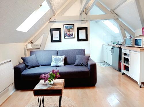 a living room with a blue couch and a table at Le Cocon proche Maisons de Champagne in Ay