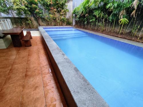 a swimming pool with a retaining wall in a backyard at Villa Dago Syariah, Familiy Only, View Indah ke Bukit Dago in Bandung