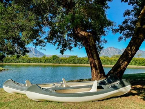 two boats sitting on the grass near a lake at La Paris Estate in Franschhoek