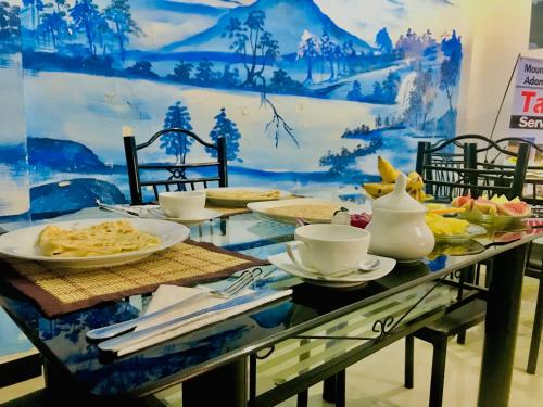 a table with plates of food on top at Mountain Villa Adam's Peak in Adams Peak