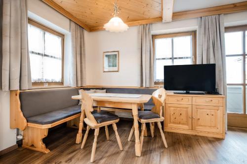 ein Esszimmer mit einem Tisch und einem TV in der Unterkunft Appartementhaus Lackner in Großarl