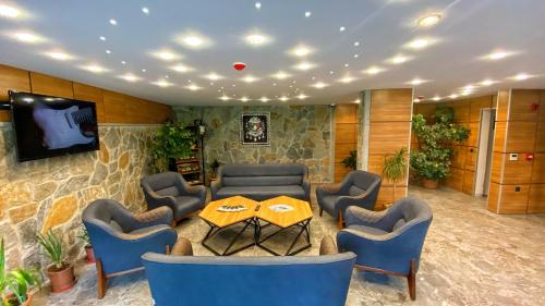 a room with a table and chairs and a tv at Heaven Suite Hotel in Trabzon