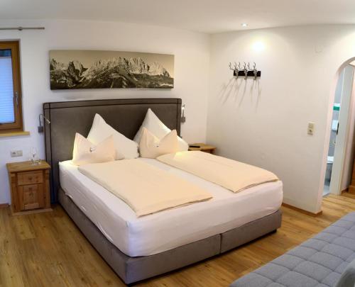 1 dormitorio con 1 cama con sábanas y almohadas blancas en Hirzinger Marlis en Going