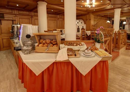 a table in a kitchen with bread and food on it at Hotel Unser Unterberg in Maria Alm am Steinernen Meer