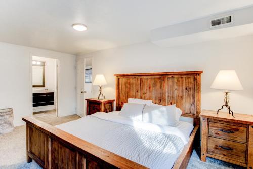 a bedroom with a large wooden bed with white sheets at Modern Private Whole Unit 4 Bedroom Guest Suite King Bed in Salt Lake City