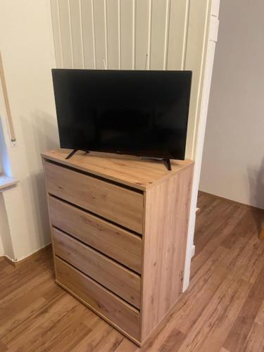 a flat screen tv sitting on top of a wooden dresser at Apartment Lingen in Lingen