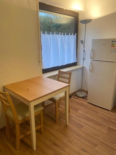 a kitchen with a wooden table and a refrigerator at Apartment Lingen in Lingen