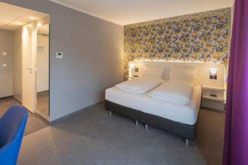 a bedroom with a bed with a floral wall at Hotel am Remspark in Schwäbisch Gmünd