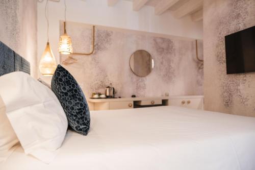 a bedroom with a white bed and a television at LUXURY SUITES ROCOPOM - Lake Front in Lecco
