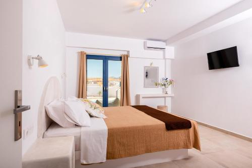 a white room with a bed and a window at Villa Waves in Monolithos