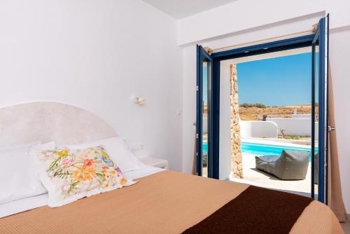 a bedroom with a bed and a view of a pool at Villa Waves in Monolithos