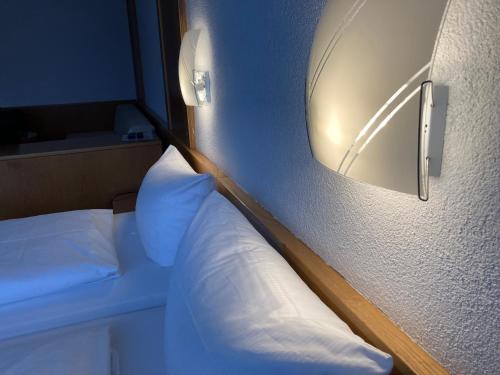 a bedroom with a bed with a mirror on the wall at Hotel JÄGERHAUS in Singen am Hohentwiel in Singen