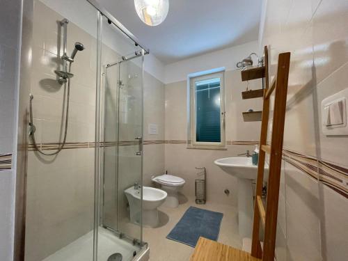 e bagno con doccia, servizi igienici e lavandino. di Costa Paestum Apartment a Paestum
