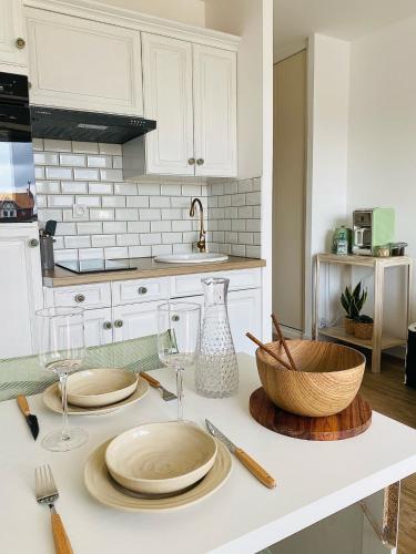 - un comptoir de cuisine avec des assiettes et des verres à vin dans l'établissement Vue mer et Garage privé, studio balcon plein Sud, à Wimereux
