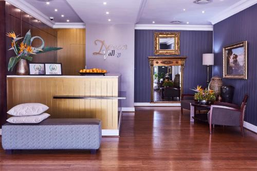 The Devon Valley Hotel في ستيلينبوش: غرفة معيشة مع أريكة وطاولة
