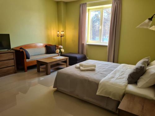 a bedroom with a bed and a living room at Grundenberga hotel with self check-in in Baldone