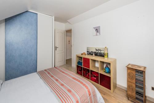 1 dormitorio con 1 cama y puerta azul en Chambres d'hôtes près de Disney, en Fontenay-Trésigny