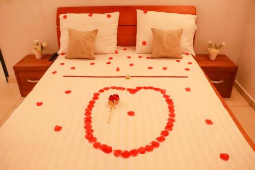 a bed with a heart made out of roses at Residence Appartements Luxueux - Angre - Abidjan in Cocody