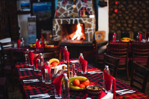 ドブリニシュテにあるAndreevi Guest Houseのテーブルクロスと果物を乗せたレストランのテーブル