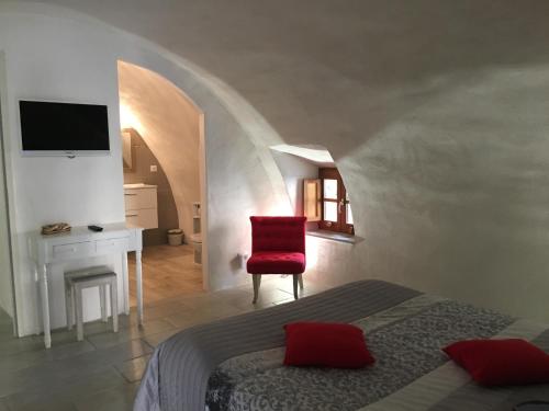 a bedroom with a bed and a red chair at Casa Natalina de caractère entièrement rénovée classée 4 étoiles in Feliceto