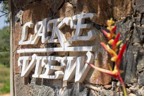 a sign on the side of a brick wall with a flower at Lake View Villa - Tangalle in Tangalle