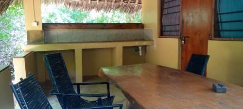 a dining room with a wooden table and chairs at Stilts Diani Beach in Diani Beach