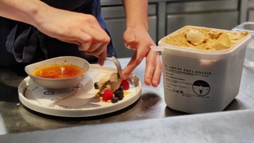 a person is preparing a bowl of food on a table at Derlon Hotel Maastricht in Maastricht