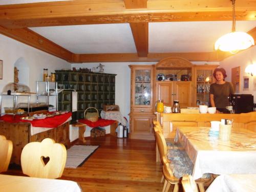 a woman standing in a kitchen with a table at Ferienhof Gindl und Gästehaus Gindl in Tauplitz