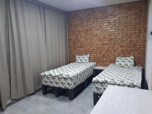 a room with two beds and a brick wall at комплекс гостиниц Athletic in Taraz