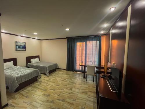 a hotel room with two beds and a desk at комплекс гостиниц Athletic in Taraz