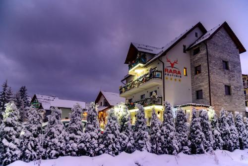 a hotel in the snow at night at Pensiune Rara Paltinis in Păltiniş