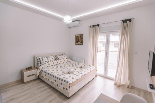 a white bedroom with a bed and a window at VS Studio Apartmani Banja Koviljača in Banja Koviljača