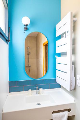 une salle de bain avec un lavabo blanc et un miroir dans l'établissement DOMAINE DE PORT AUX ROCS, au Croisic
