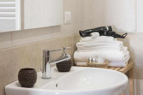 uma casa de banho com lavatório, espelho e toalhas em Masseria Fanizzi em Conversano
