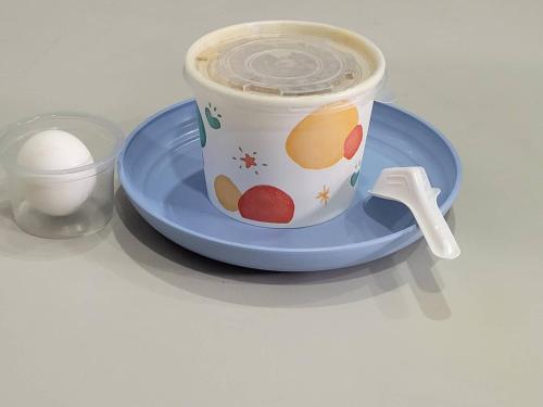 a cup of coffee on a blue plate with a spoon at 花蓮亮君經典民宿1館加2館民宿-東大門夜市-電梯包棟Bright King Homestay in Hualien City
