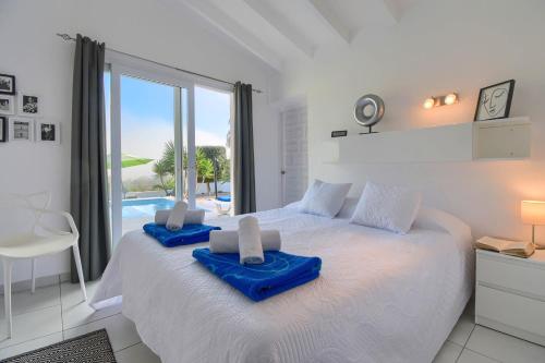 Un dormitorio con una cama blanca con toallas azules. en Mi Sueño, en Moraira