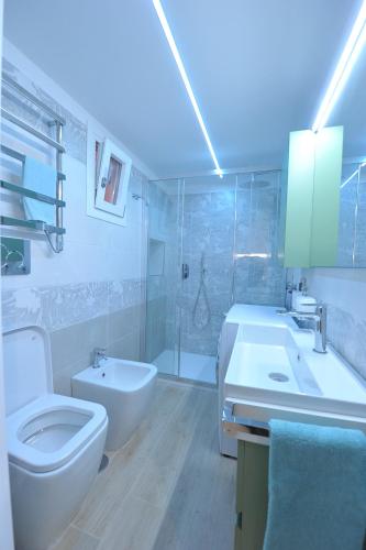 a white bathroom with a toilet and a sink at Little Dream in Piano di Sorrento