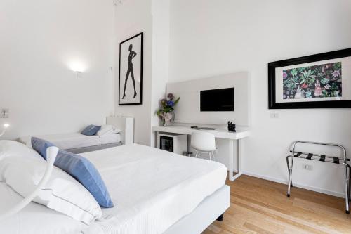 Biała sypialnia z 2 łóżkami i biurkiem w obiekcie Calapetra Resort w mieście Fontane Bianche