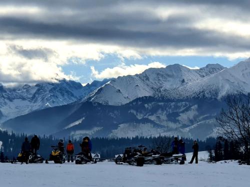 a group of people standing in the snow in the mountains at Willa Pasieka Apartamenty Domki in Bukowina Tatrzańska