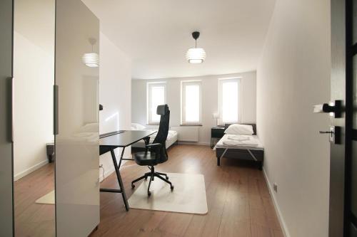 a room with a desk with a chair and a bed at Apartamenty 110 Okrąglak Stronie Śląskie in Stronie Śląskie
