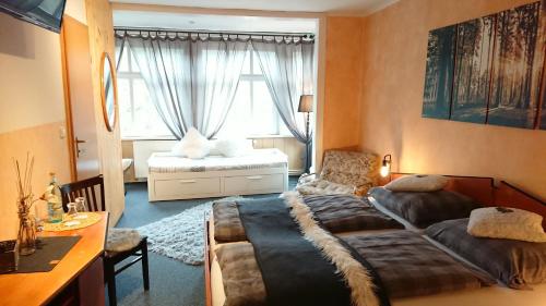Schlafzimmer mit einem Bett, einem Schreibtisch und einem Fenster in der Unterkunft Pension Waldschlösschen in Friedrichroda