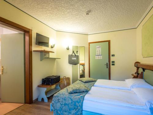 Una cama o camas en una habitación de Albergo Dimaro Wellness Hotel