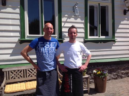 two men are standing in front of a house at Hotel & Restaurant Druidenstein in Trautenstein
