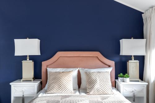 a bedroom with blue walls and a bed with two lamps at Przystań Stegna in Stegna