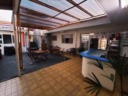 a living room with a table and chairs and a ceiling at Nova Pousada Consulado in Ponta Grossa