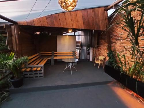 a patio with a table and bench and a screen at Nova Pousada Consulado in Ponta Grossa