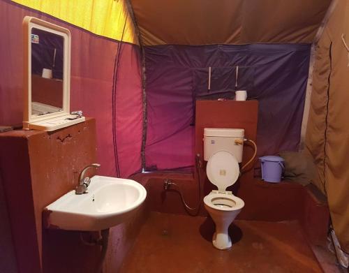 a bathroom with a toilet and a sink in a tent at StayApart - Deccan Trails Vikarabad in Vikārābād