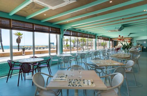 een restaurant met tafels en stoelen en de oceaan bij Medplaya Hotel Pez Espada in Torremolinos
